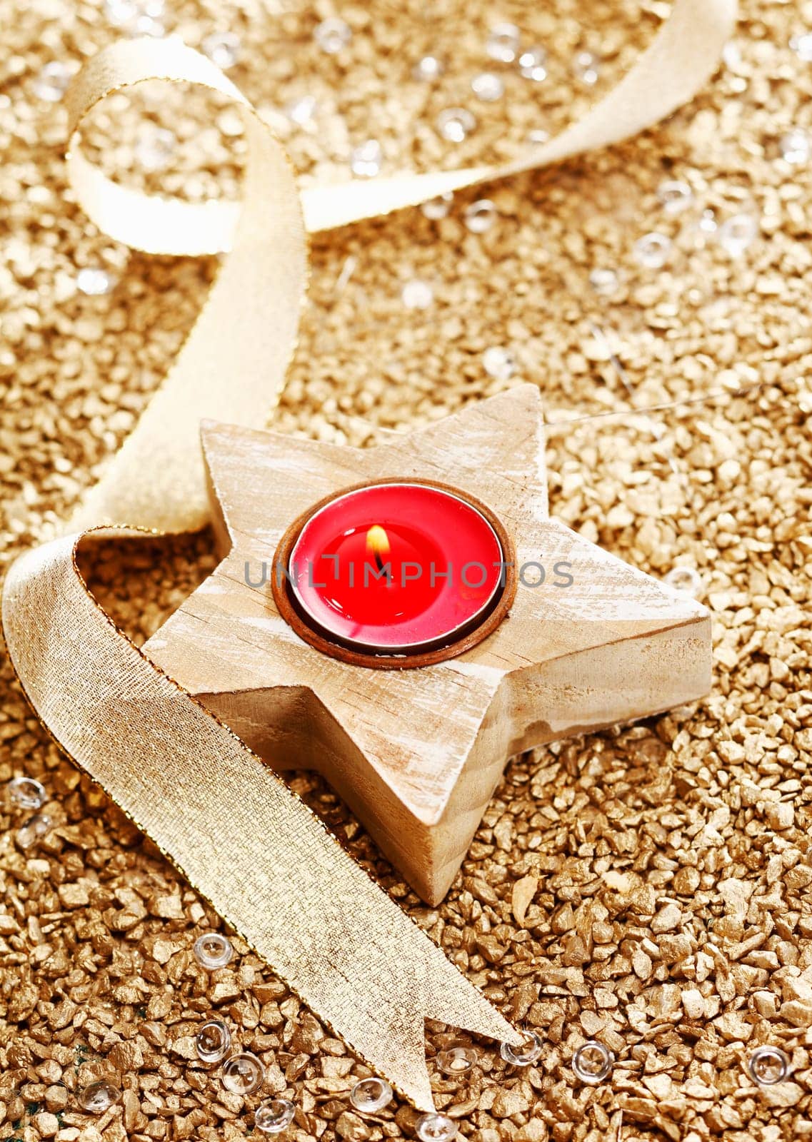 Christmas Candle with a golden bow on a festive background