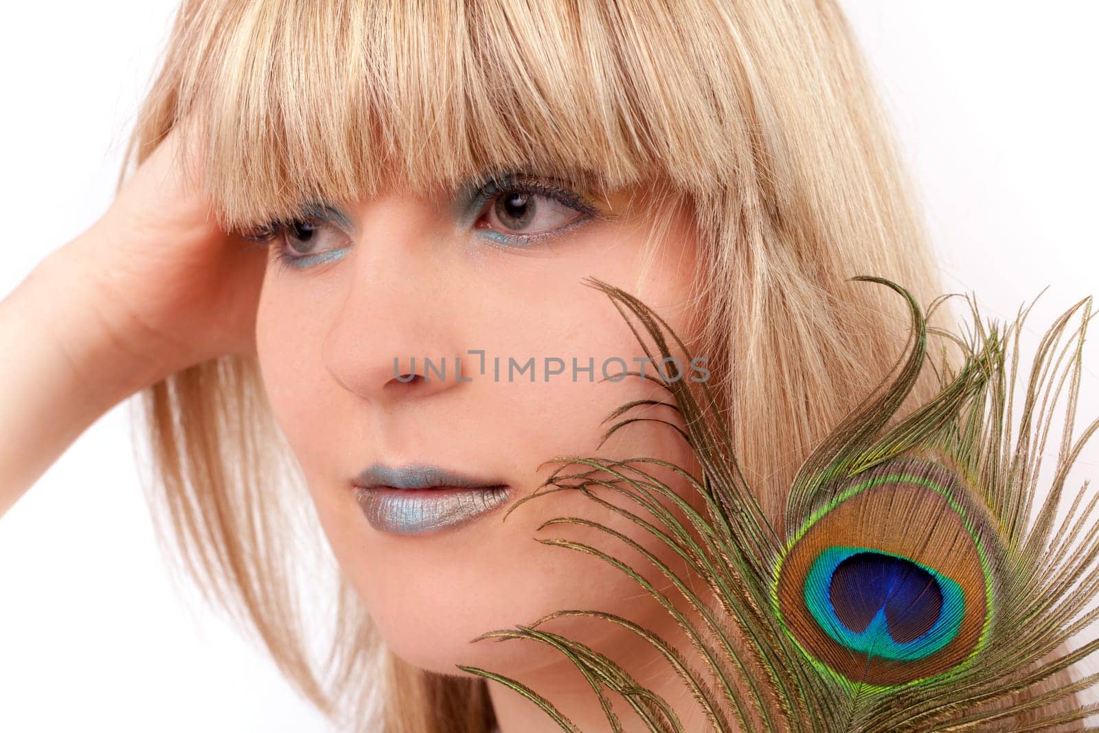 Young woman with peacock feather