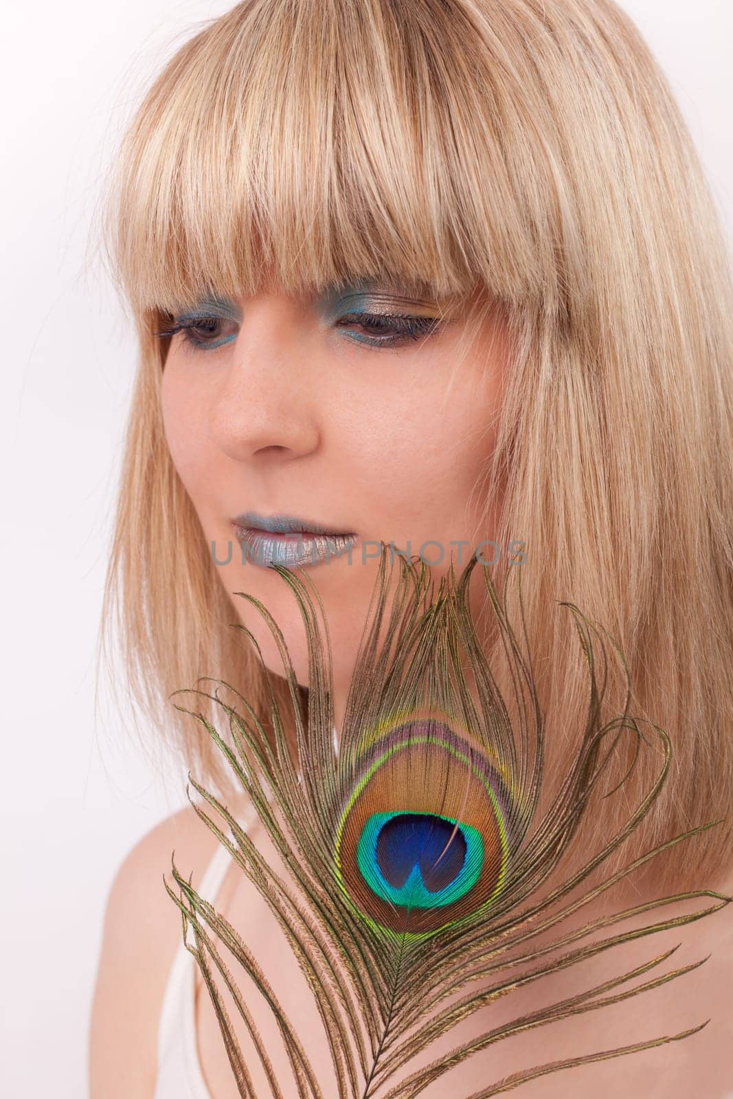 Young woman with peacock feather