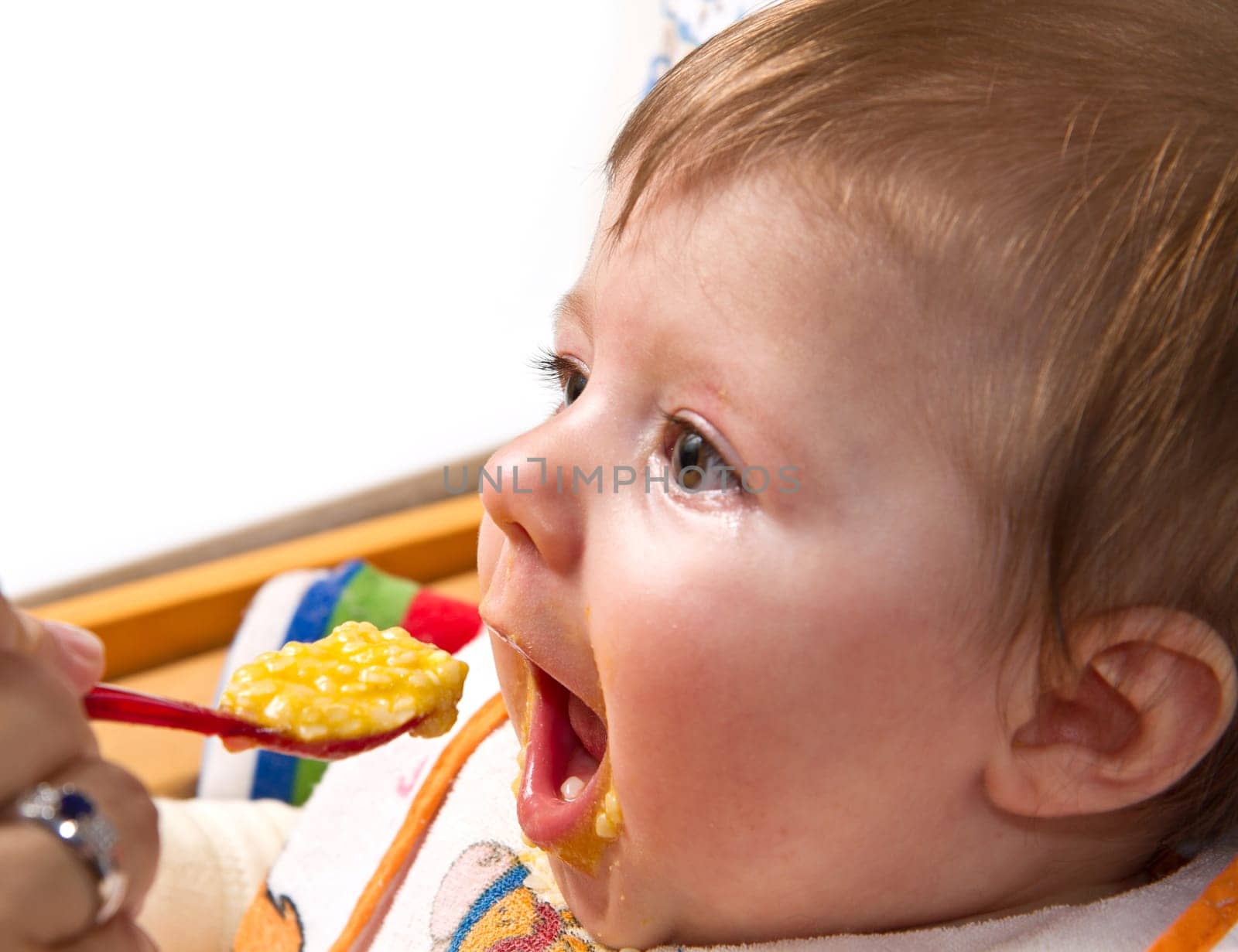 Little boy eating baby food with spoon