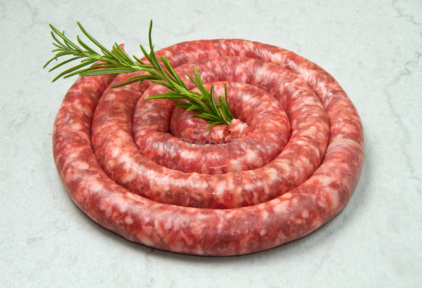 fresh raw sausage with rosemary on marble  background