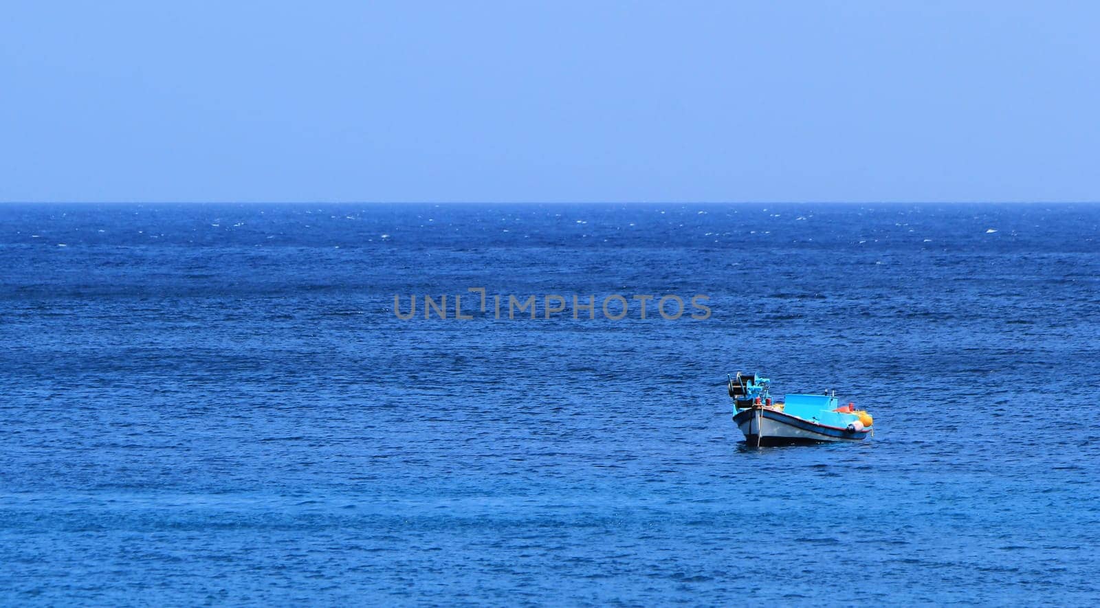 Colorful small boat alone on the calm sea by beautiful weather