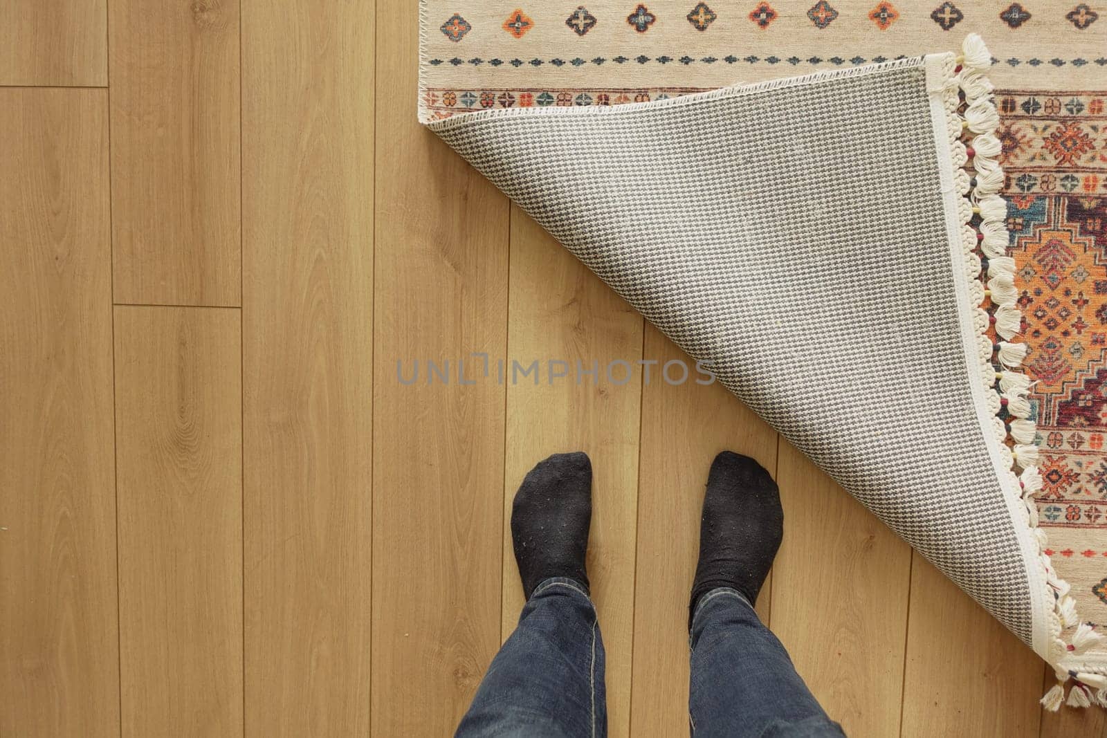 The rug is being pulled back to reveal the wooden floor beneath.