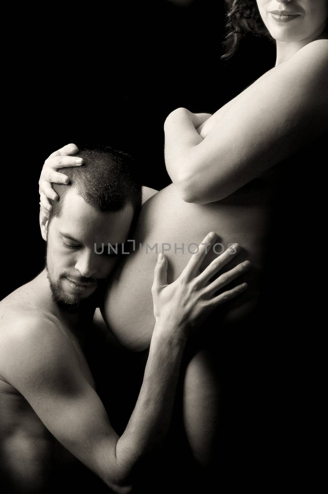 Beautiful pregnant couple against a dark background