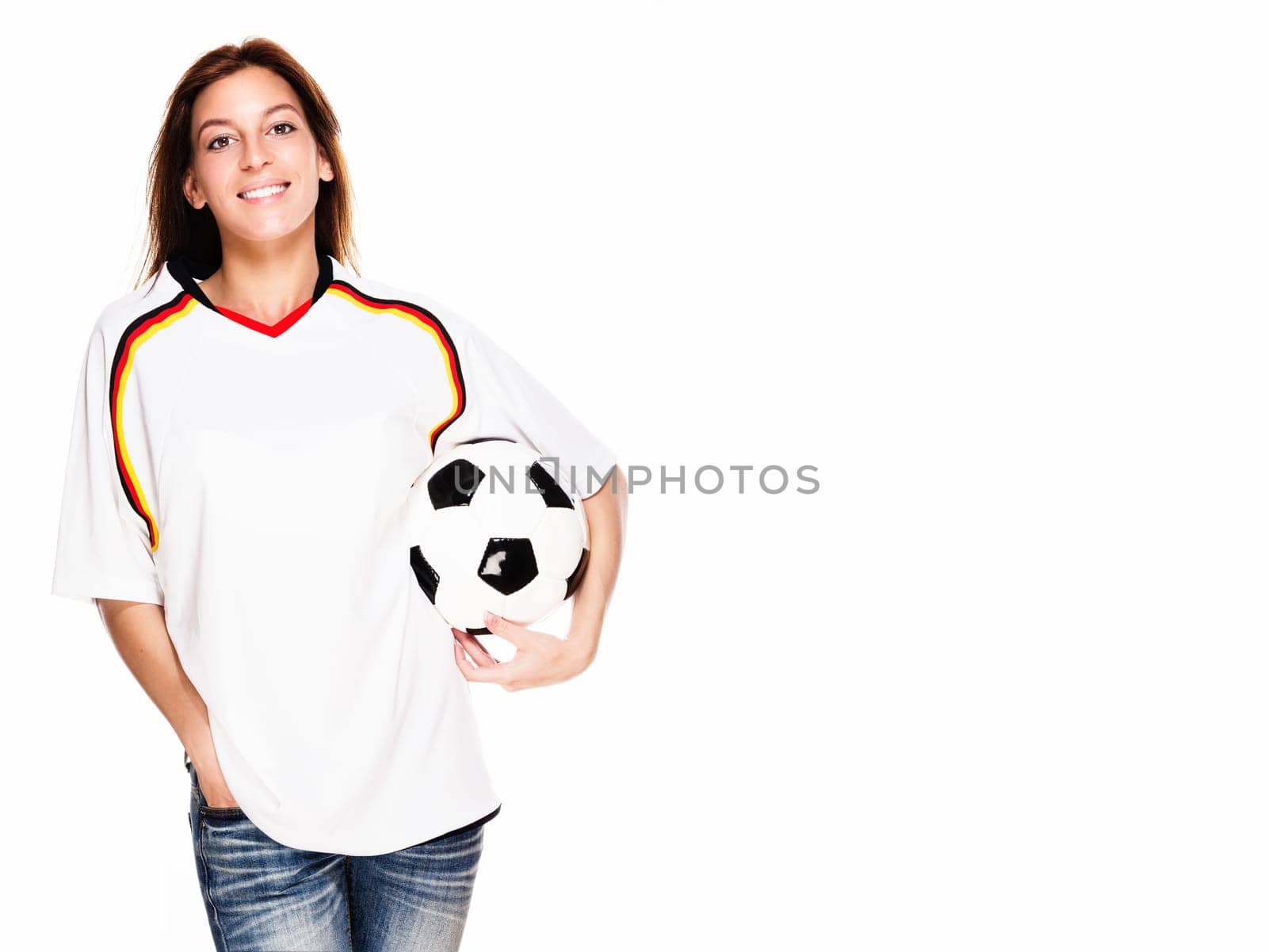 Happy young woman with soccer ball wearing jersey against white background