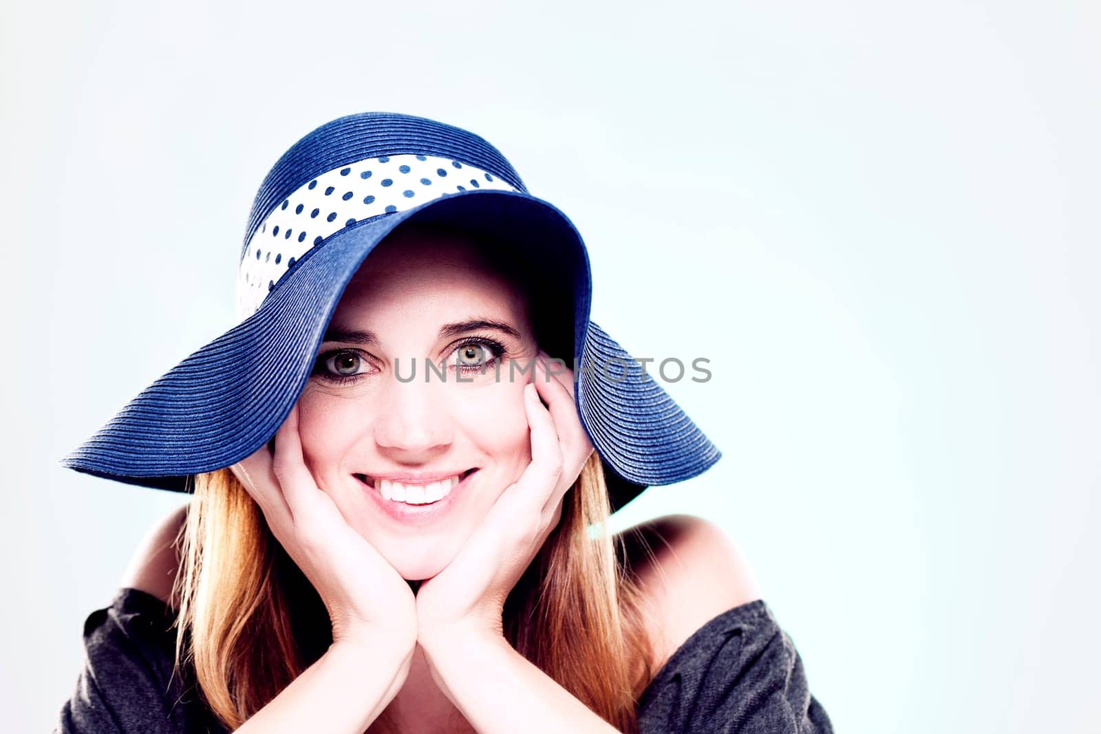 Happy woman with summer hat against light background