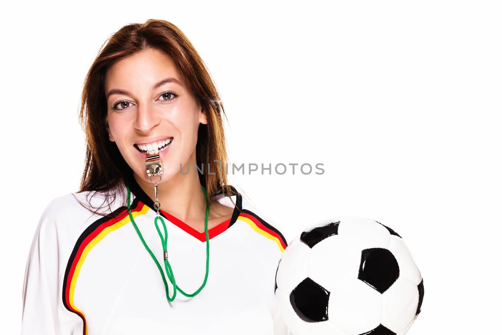 Young woman in soccer jersey with whistle holding soccer ball against white background