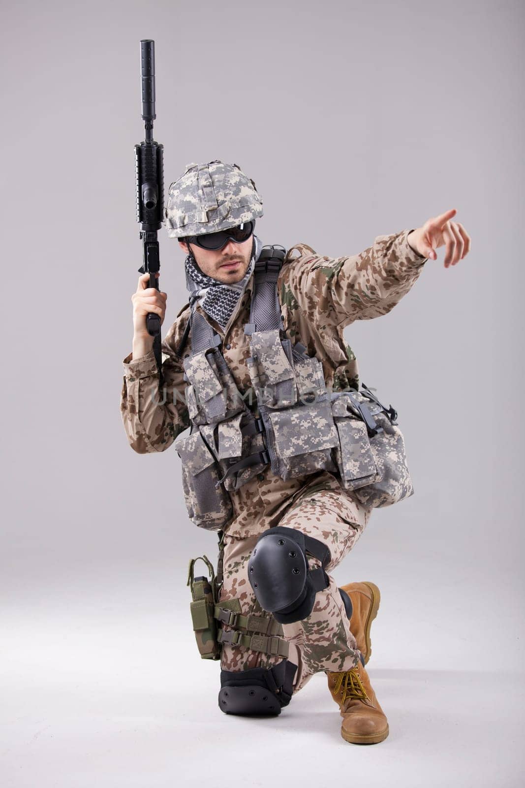 Armed Soldier in camouflage pointing with a finger