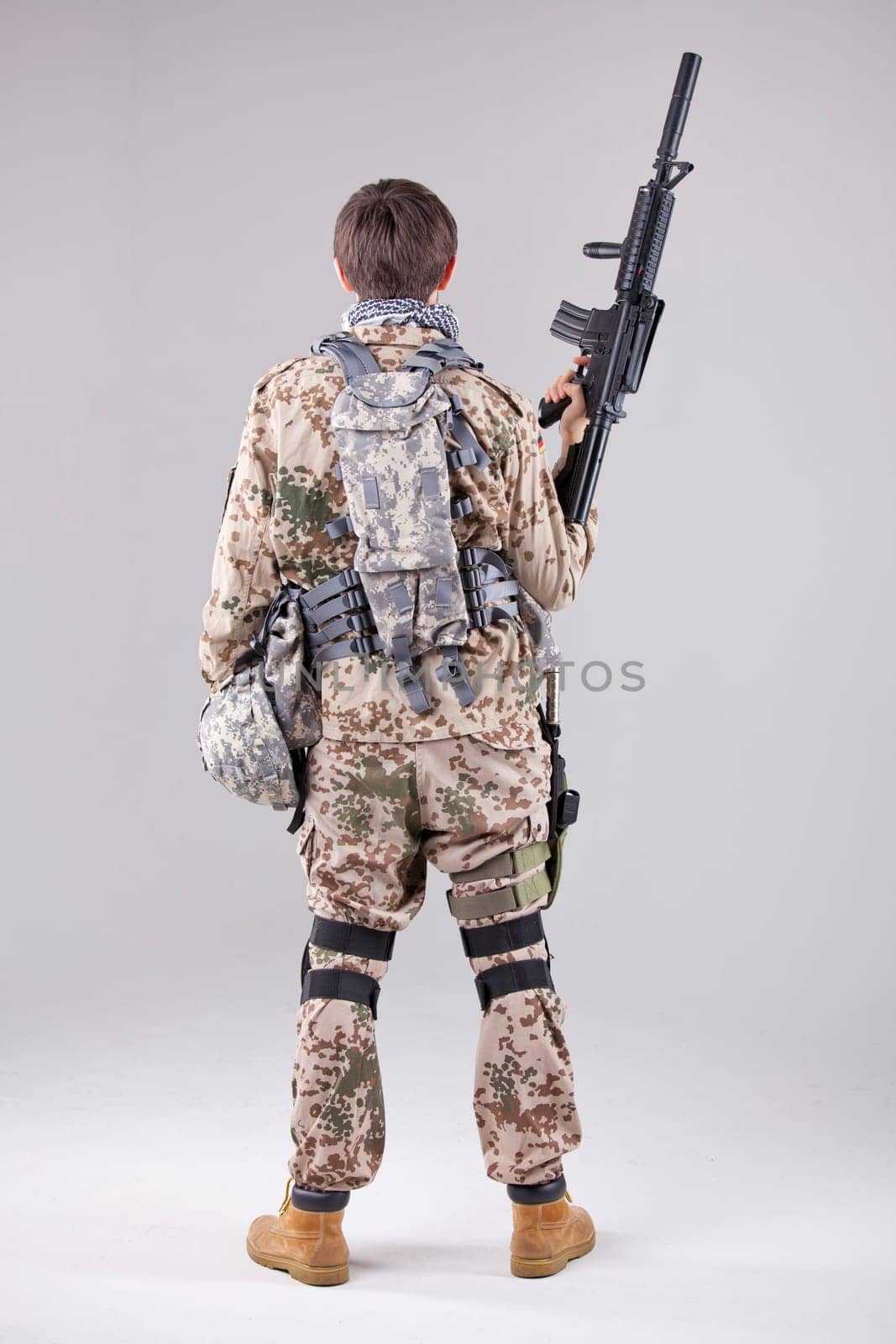 Soldier with machine gun - shot from behind over white