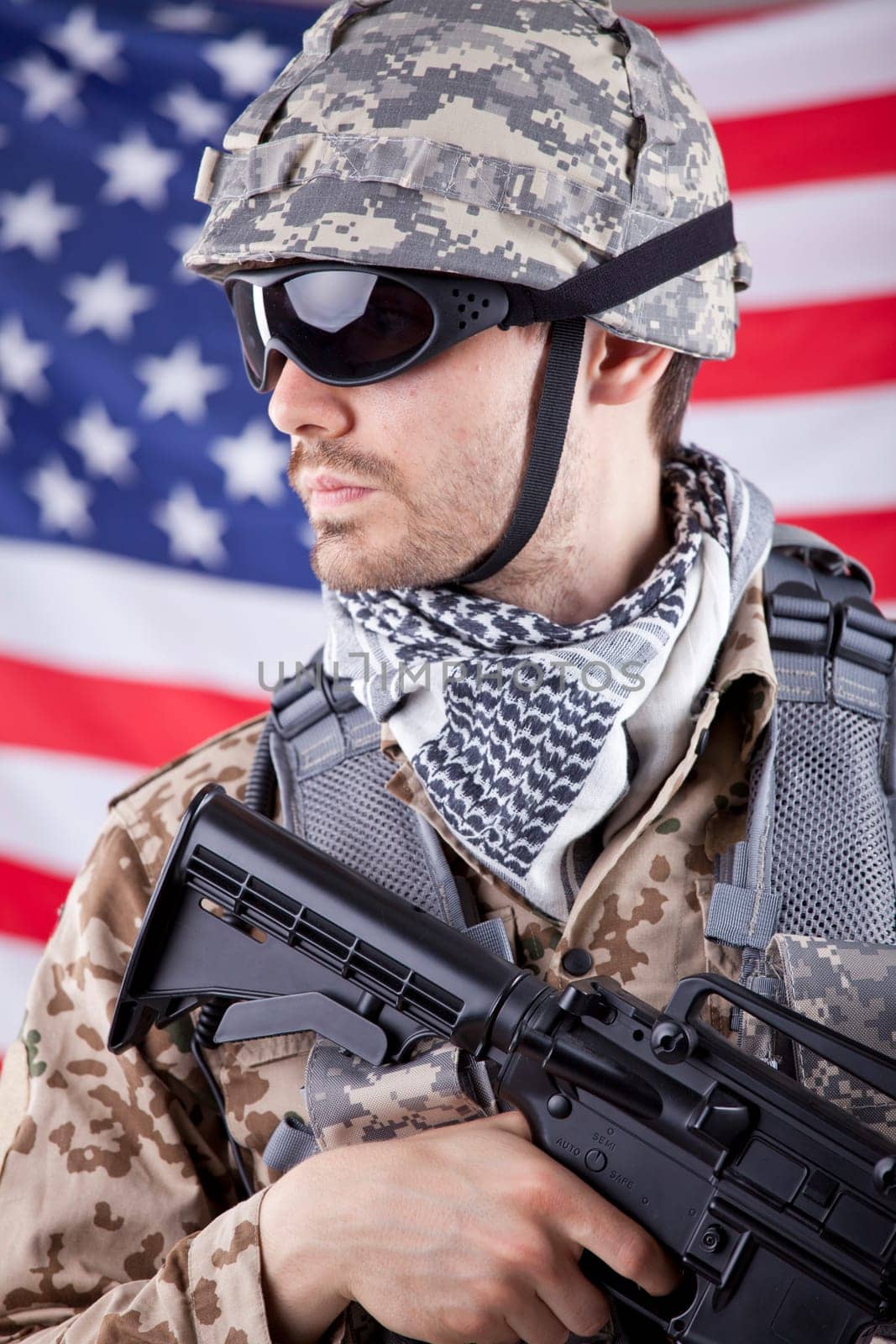 American soldier in camouflage with machine gun over american flag