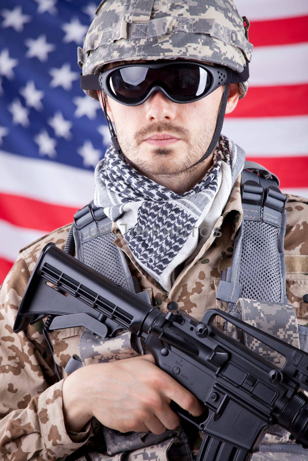 Portrait of armed american soldier in camouflage over american flag
