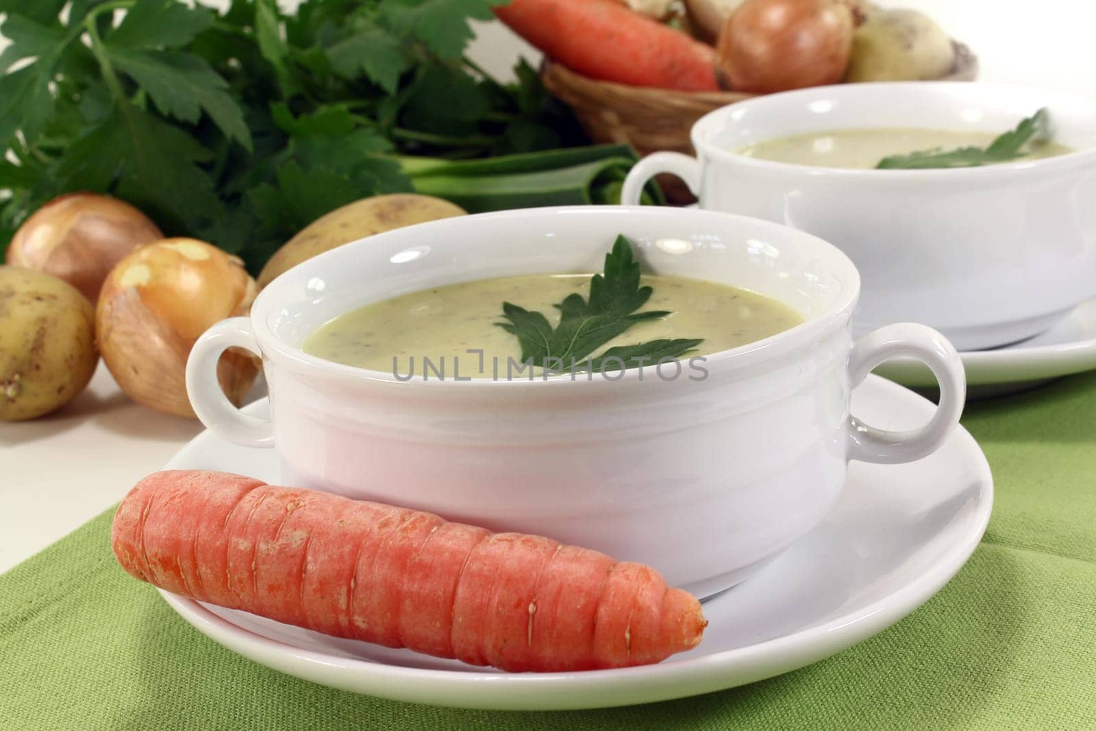 two cups of vegetable cream soup with parsley