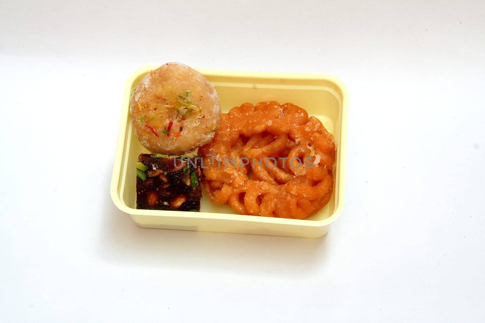 Assortment of Indian sweets in a tray isolated on white