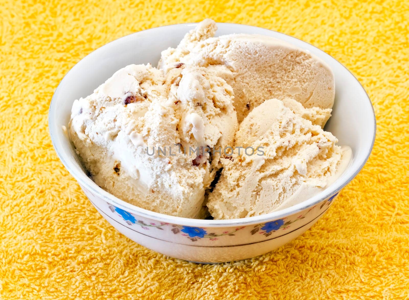 vanilla ice cream with nuts in a container on a yellow background