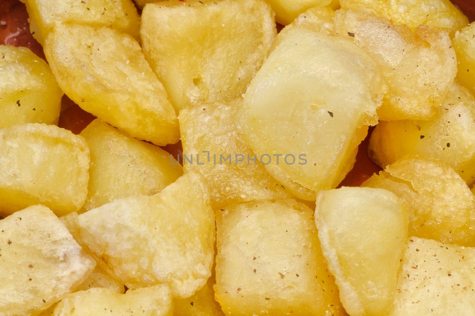 Fried pieces of potatoes with oil , dill pepper and salt. plate with typical spanish patatas bravas.