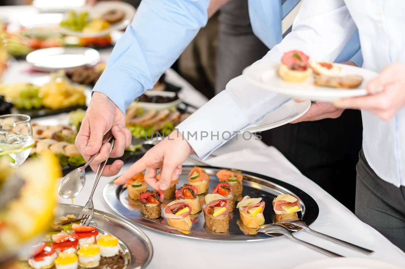 Catering at business company event people choosing buffet food appetizers