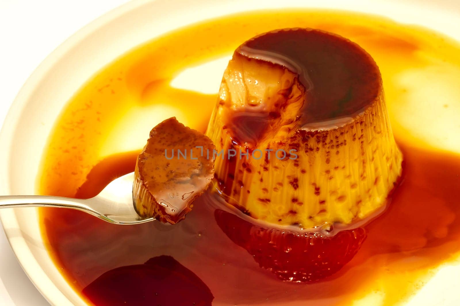 Delicious vanilla cream, egg custard with caramel sauce, and spoon