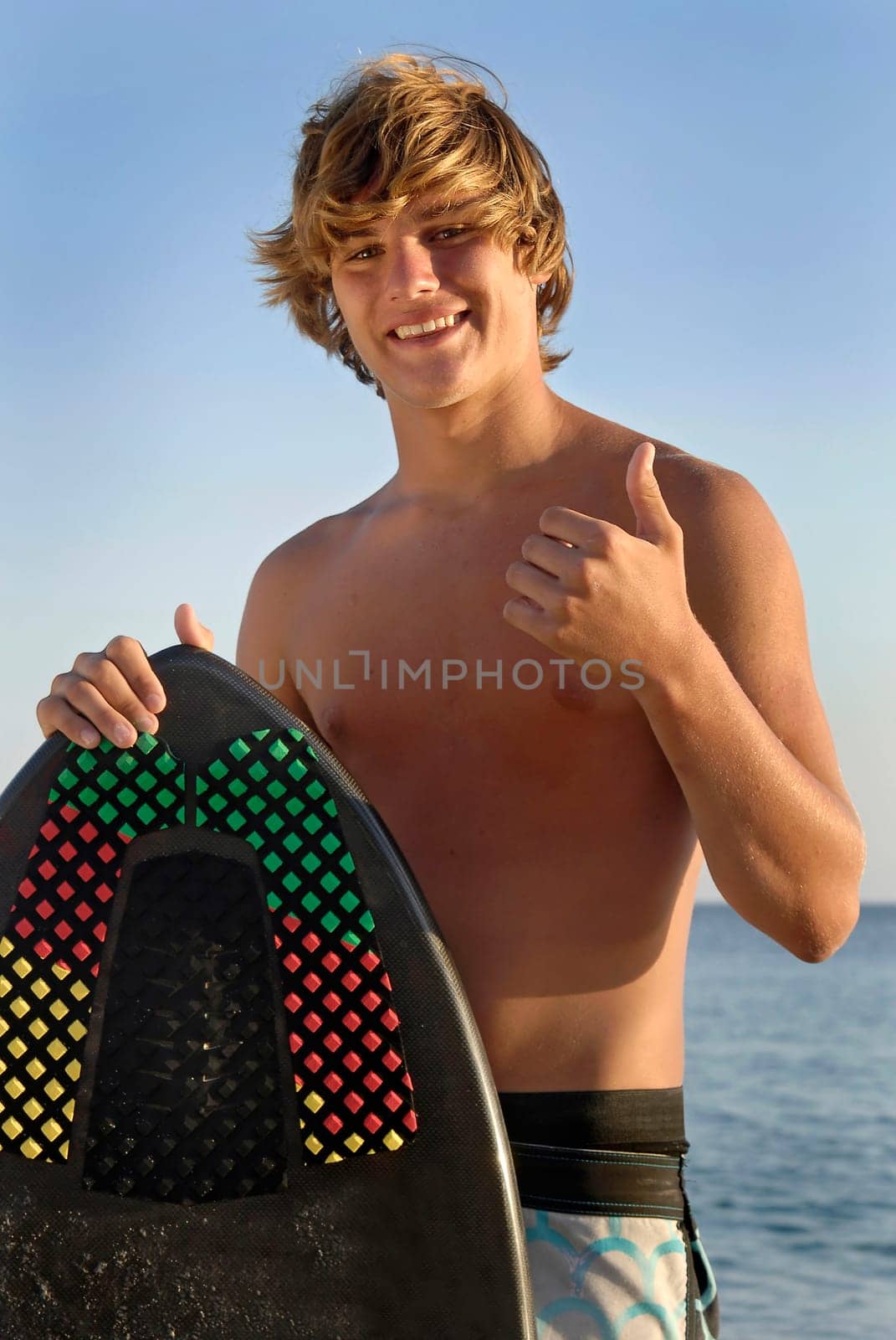 Handsome surfer posing in the beach