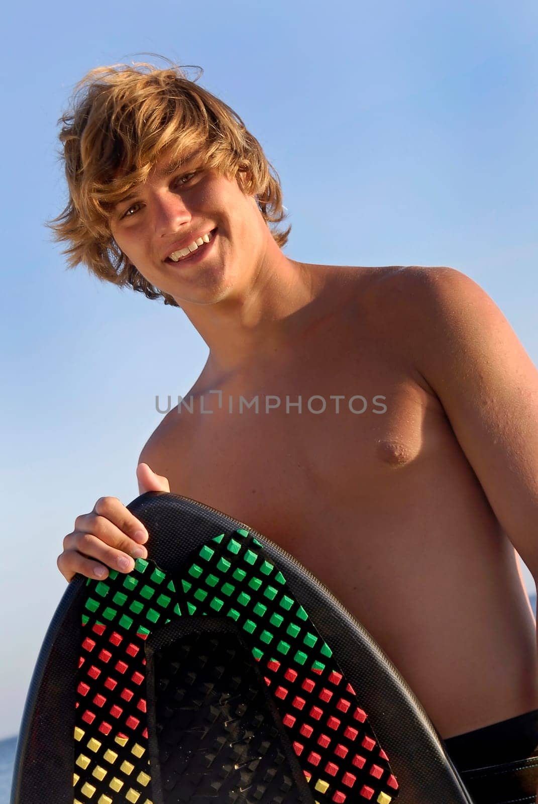Handsome surfer posing in the beach