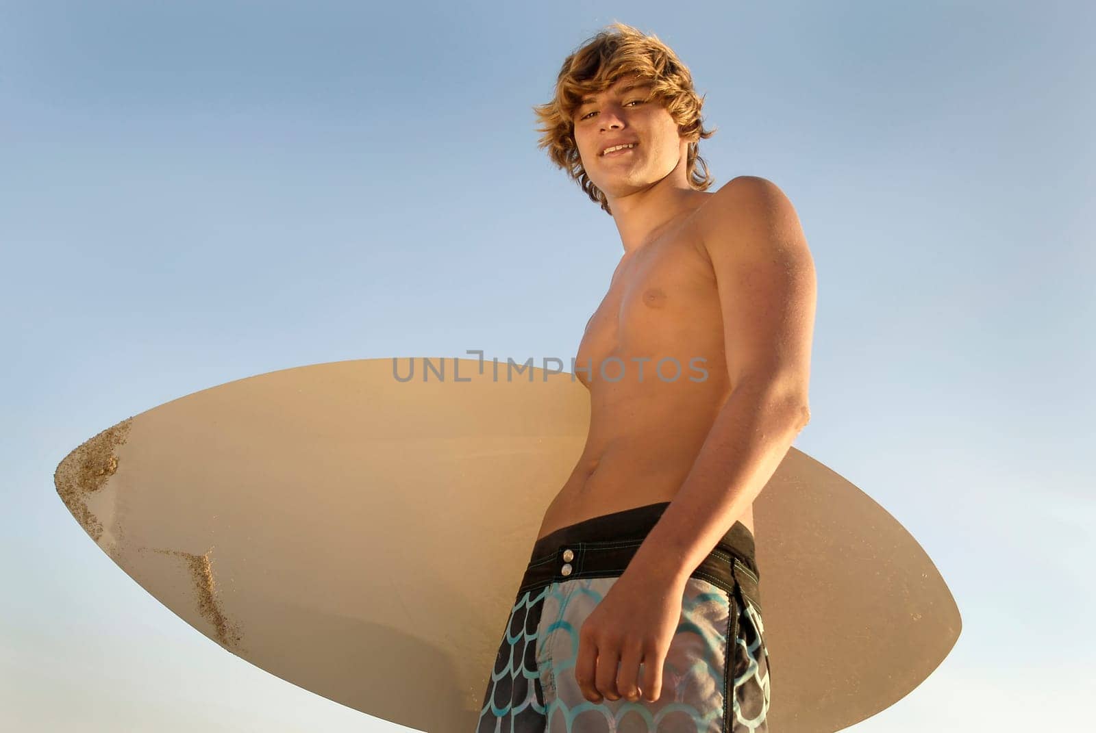 Handsome surfer posing in the beach