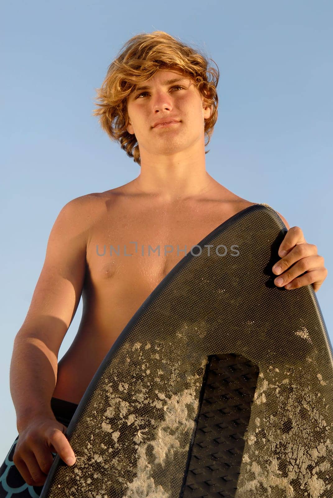 Handsome surfer posing in the beach