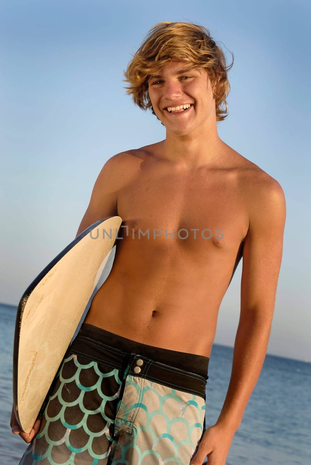 Handsome surfer posing in the beach