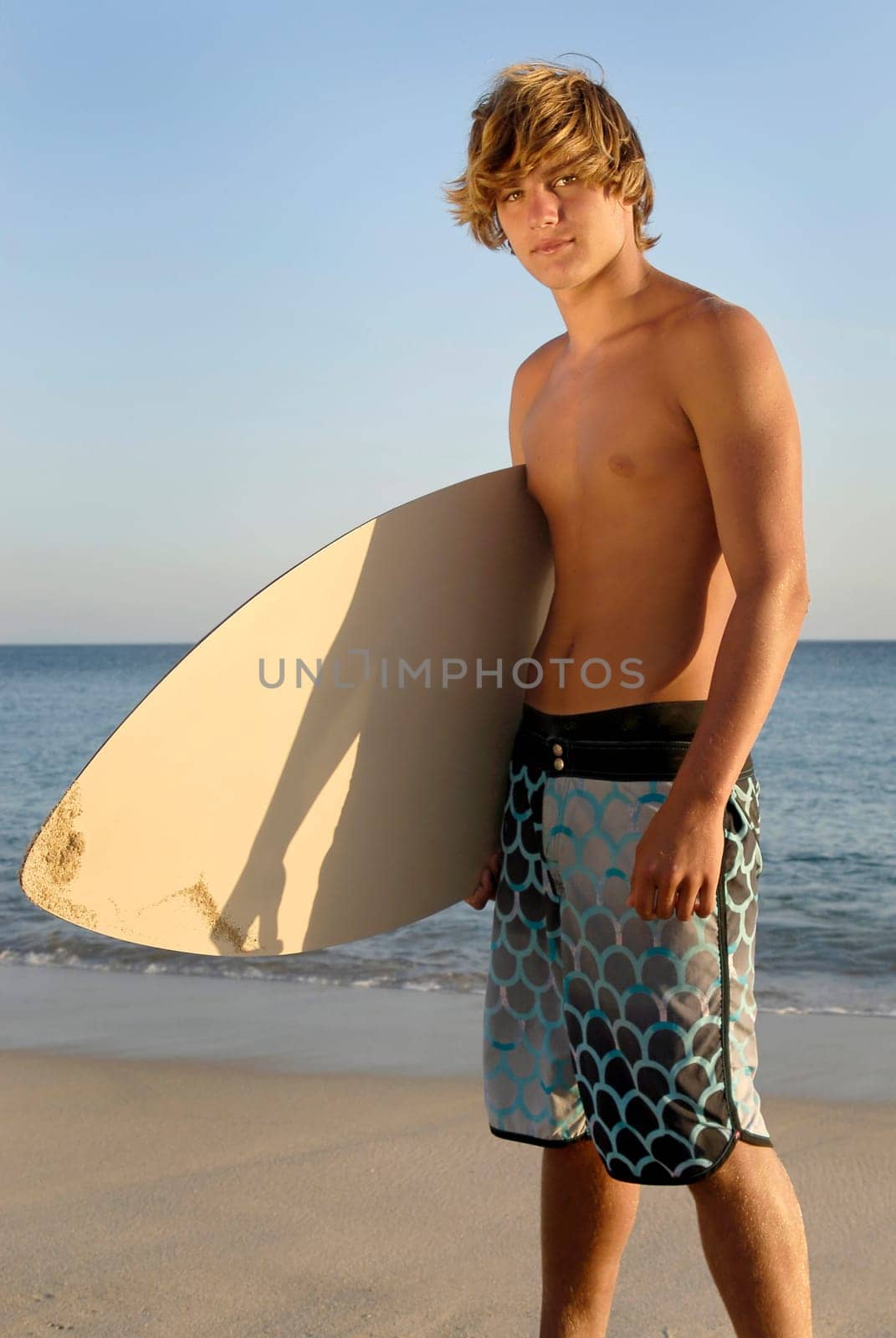 Handsome surfer posing in the beach