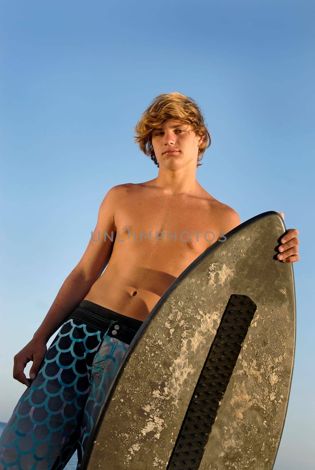 Handsome surfer posing in the beach