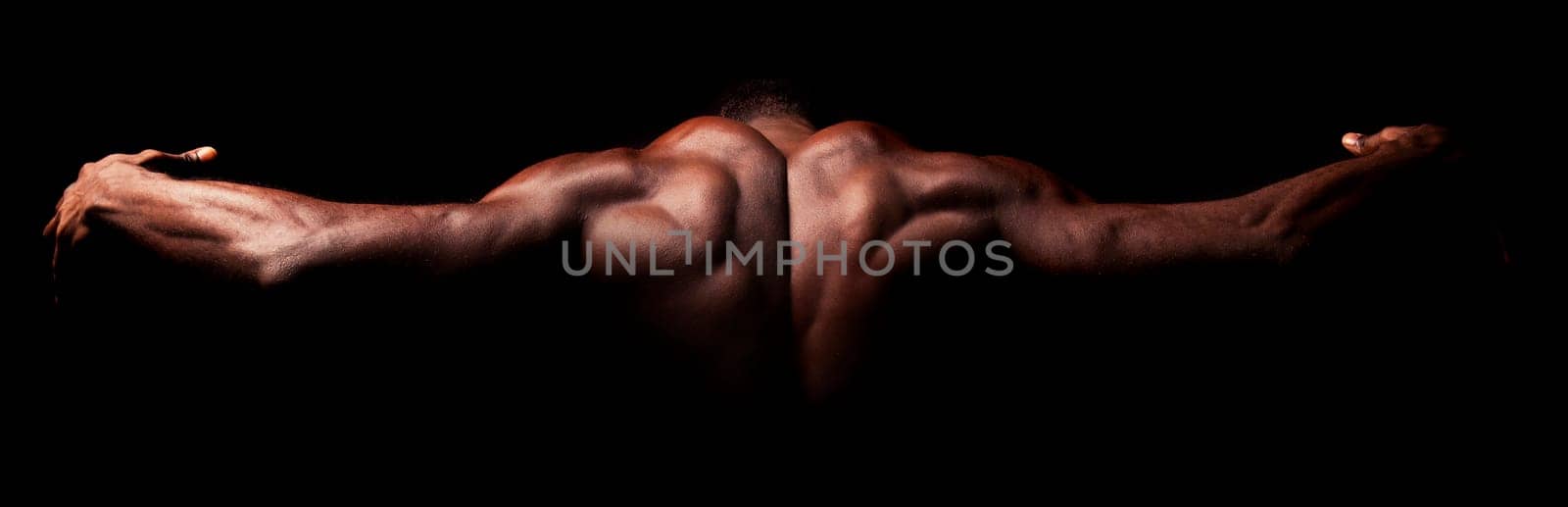 Beautiful and muscular black man's back in dark background
