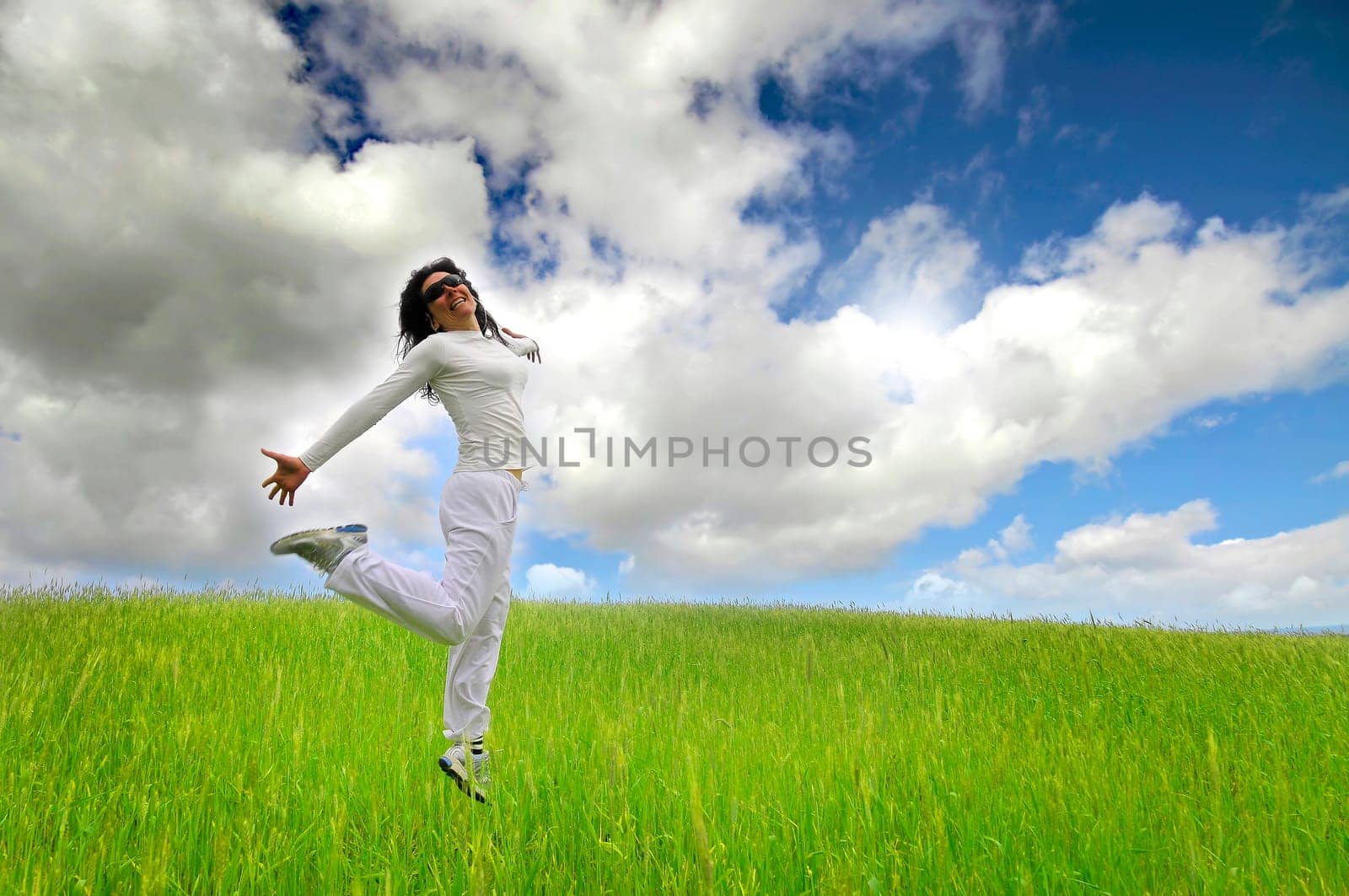 Woman jumping high in a green field