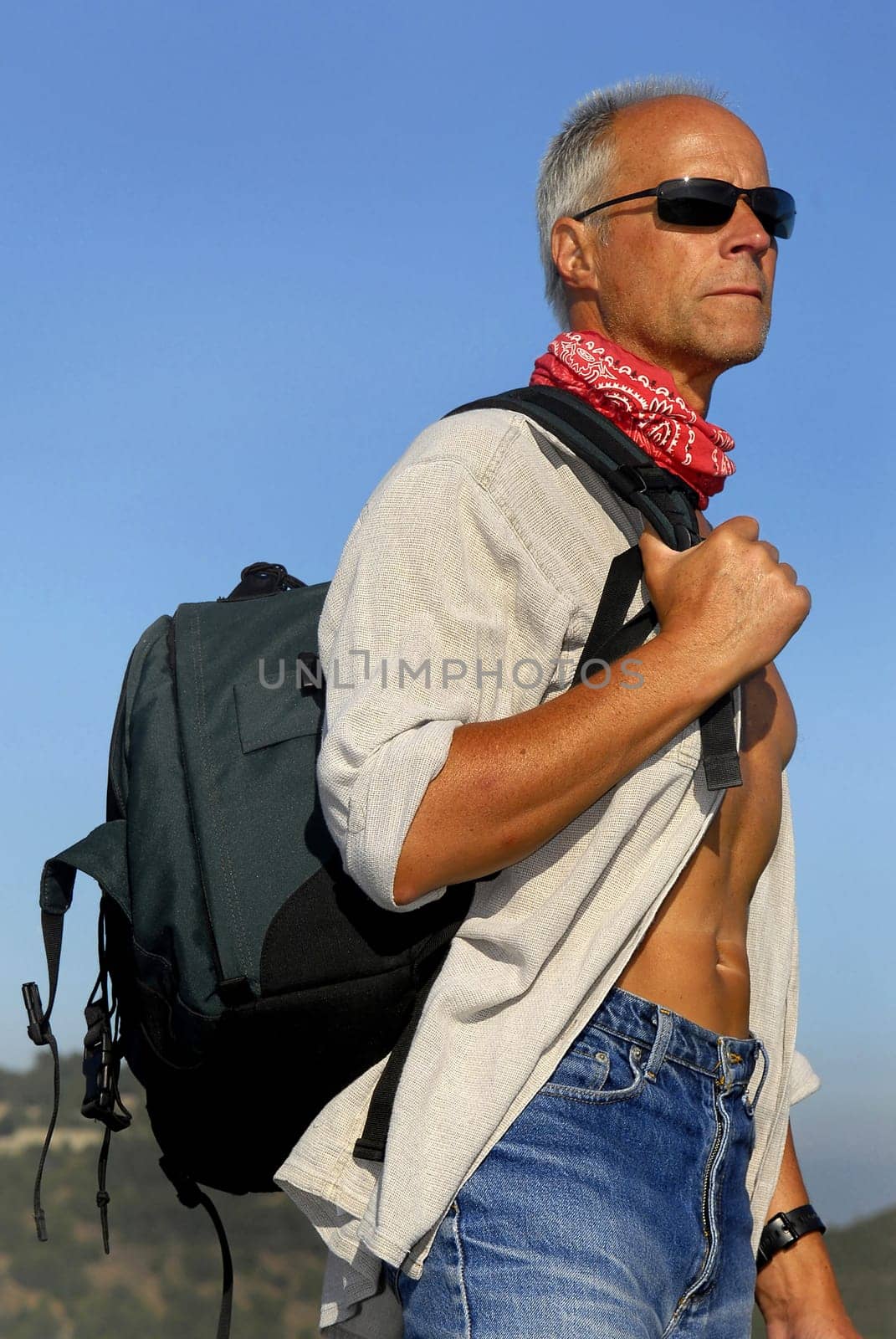 Handsome mature man adventurer with a backpack outdoors