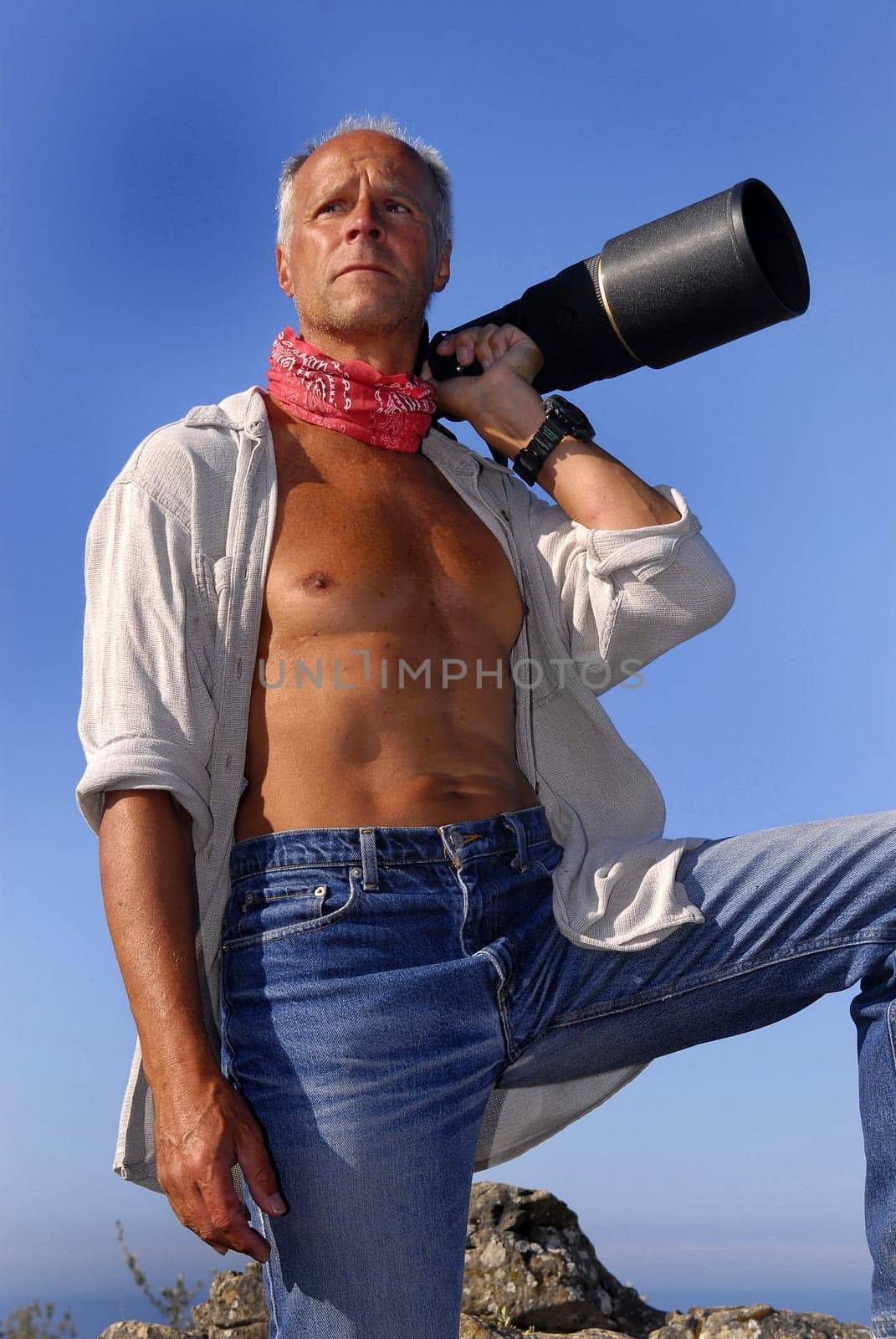 Handsome mature model posing with a big camera outdoors