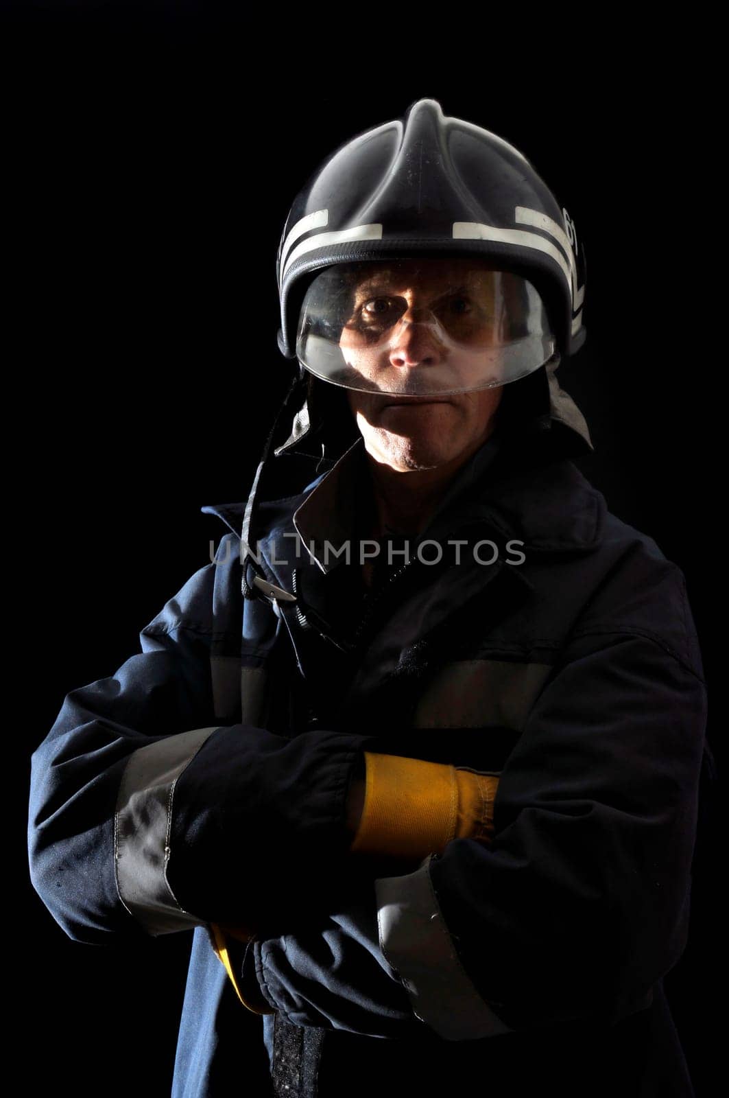 Fireman in uniform isolated in black