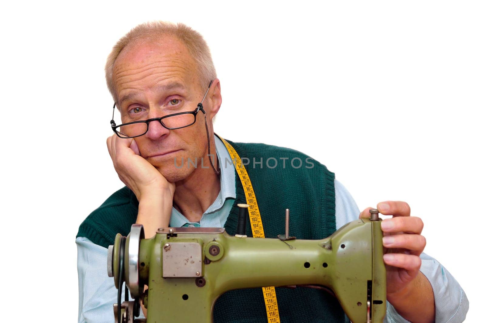 Mature tailor with a sewing machine isolated in white