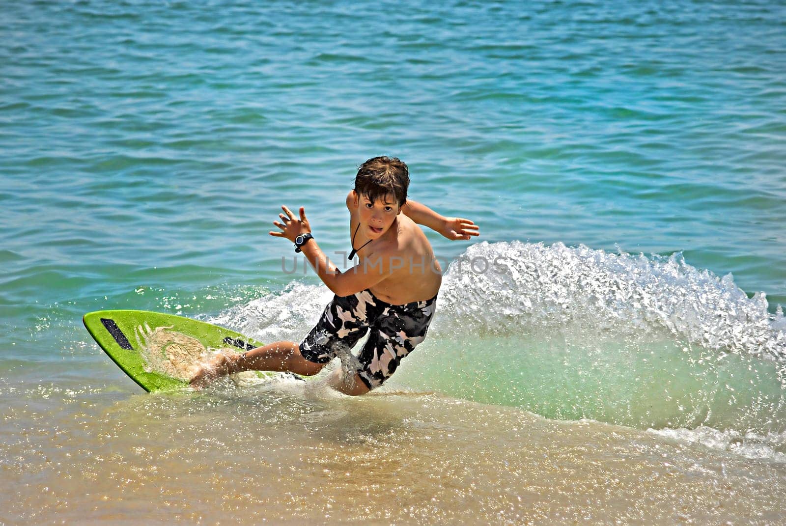 Boy jumping in the air with skimboard in the sea