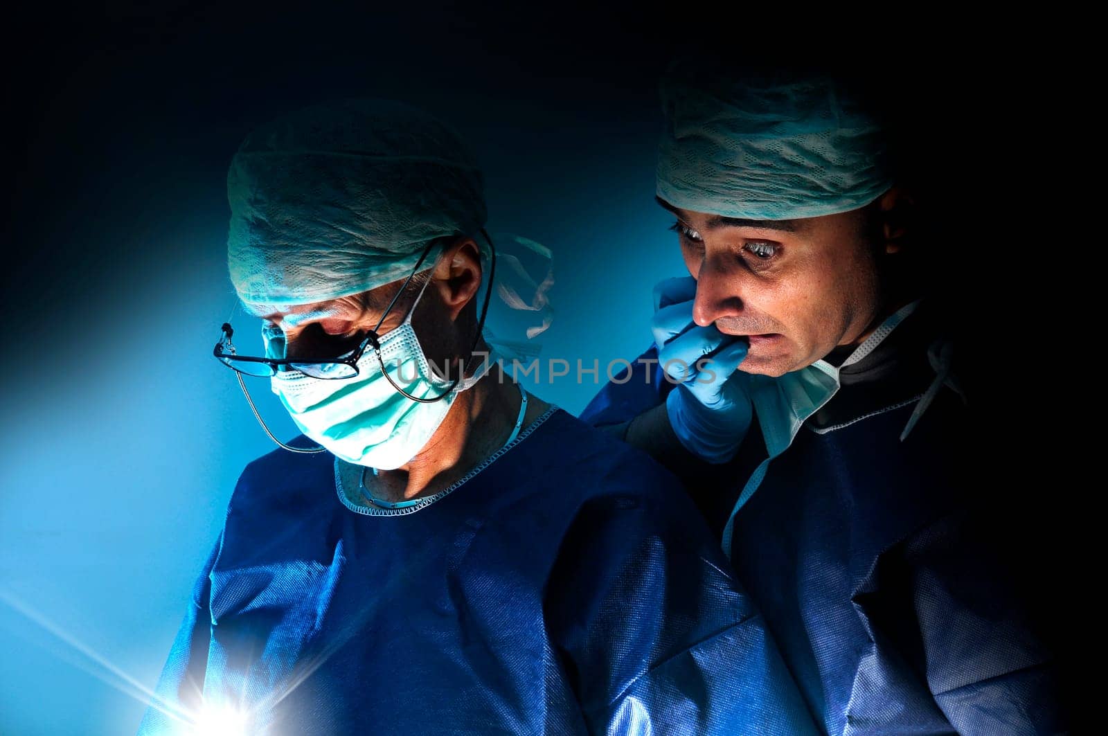 Doctors team in surgery in a dark background