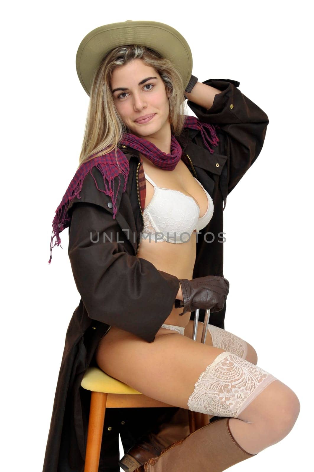 Sexy girl in cowboy outfit in a chair isolated in white