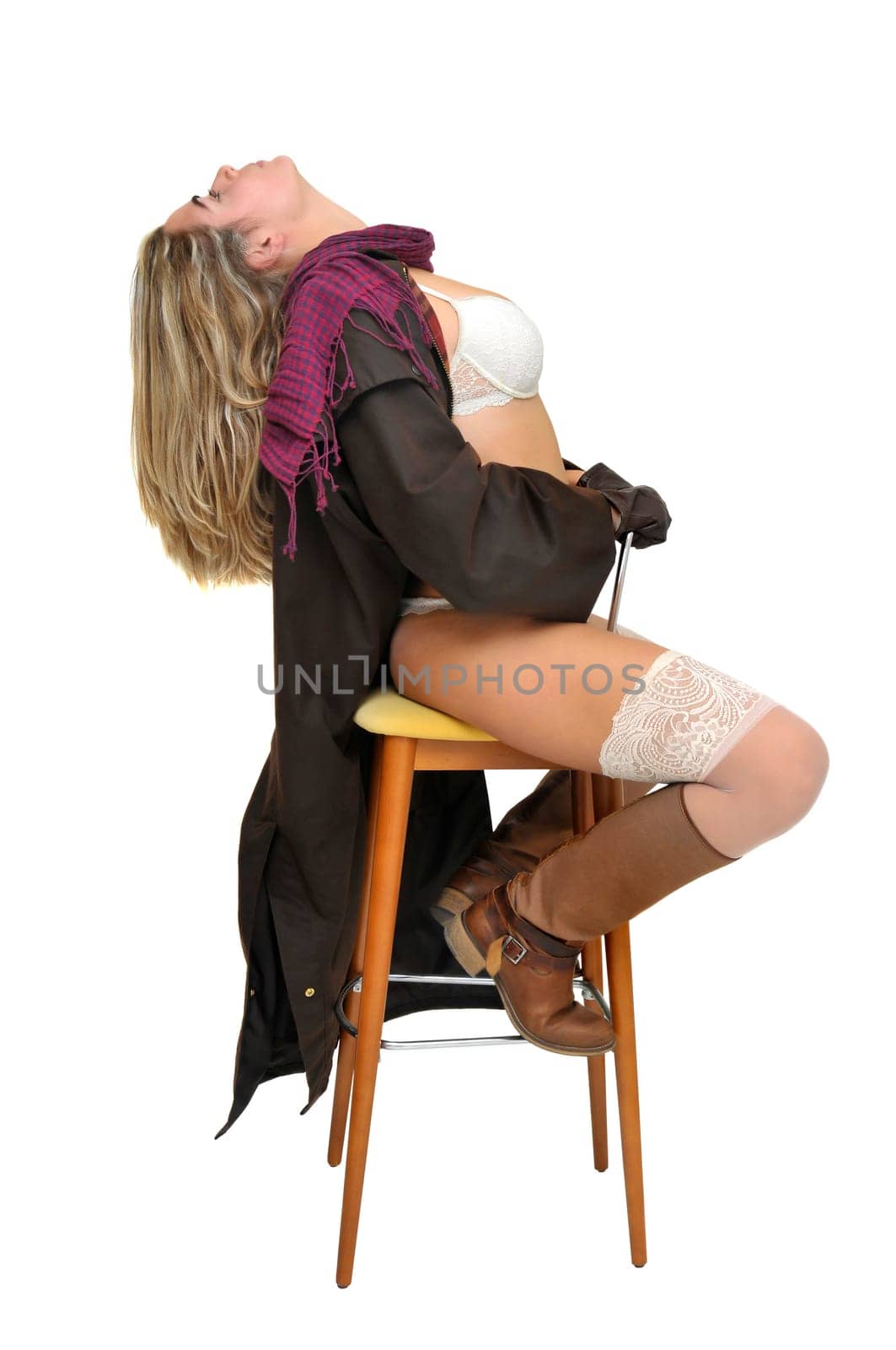 Sexy girl in cowboy outfit in a chair isolated in white