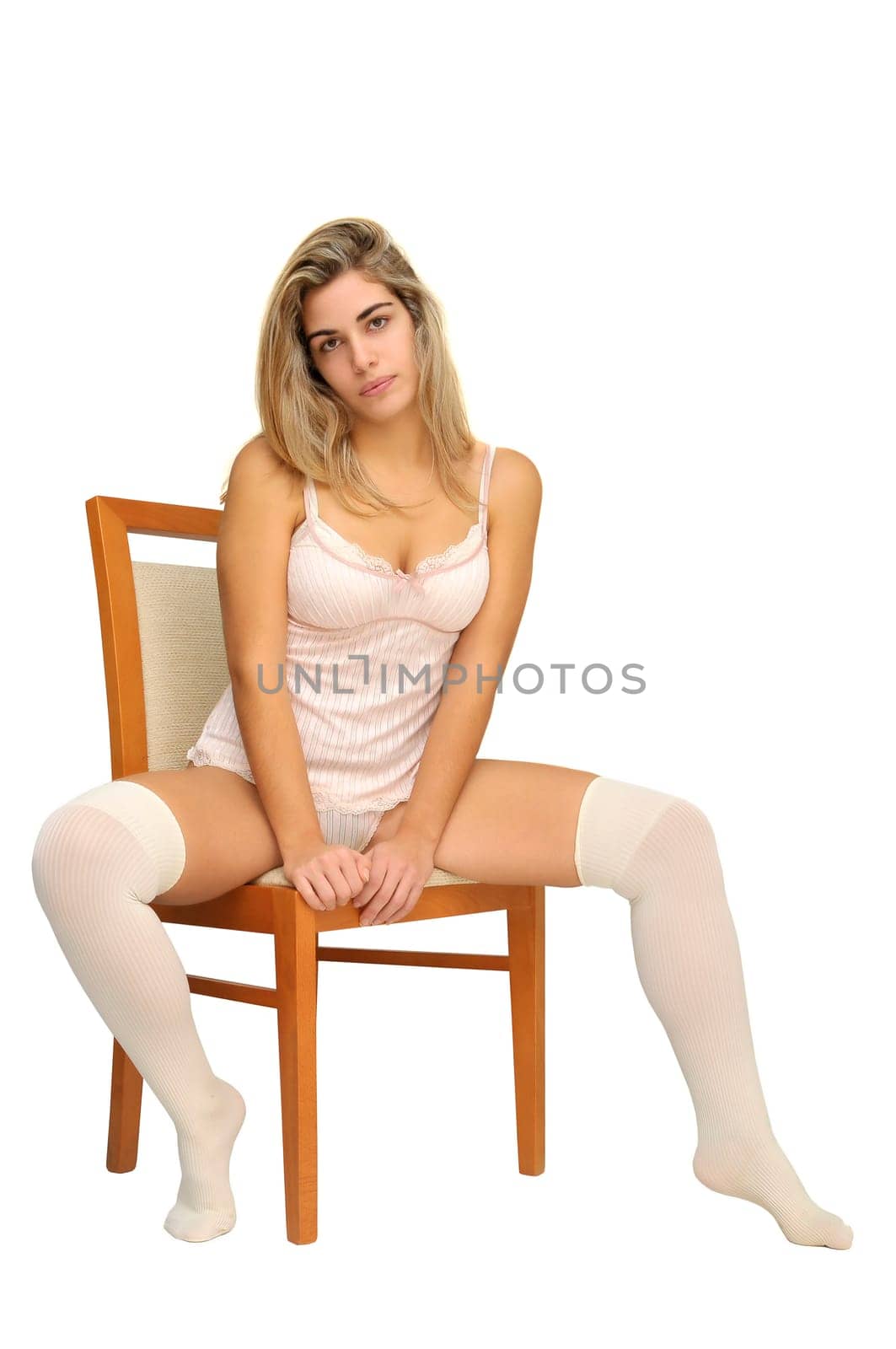 Sexy girl in white and pink lingerie seated in a chair isolated in white