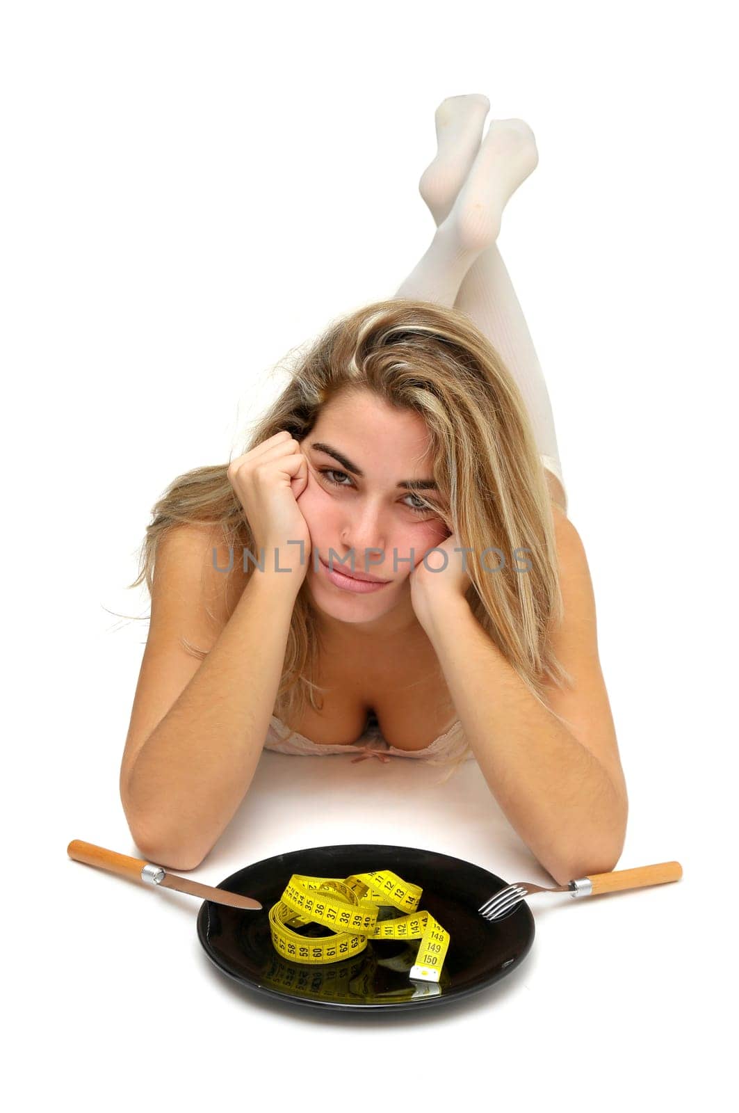 Sexy girl with measuring tape in a dish and no food isolated in white
