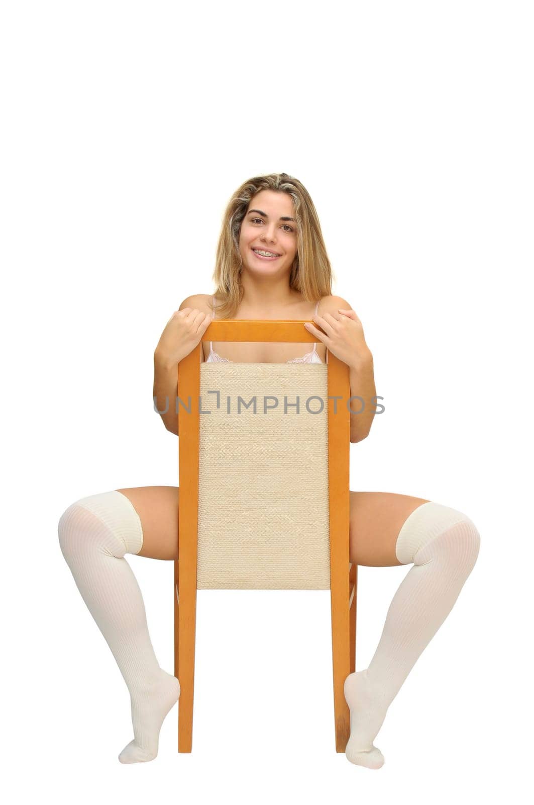 Sexy girl in white lingerie seated in a chair isolated in white
