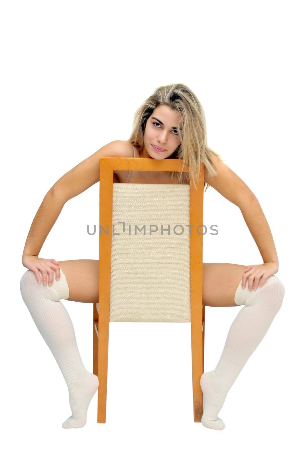Sexy girl in white lingerie seated in a chair isolated in white