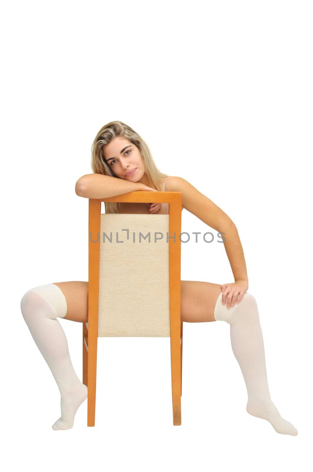 Sexy girl in white lingerie seated in a chair isolated in white