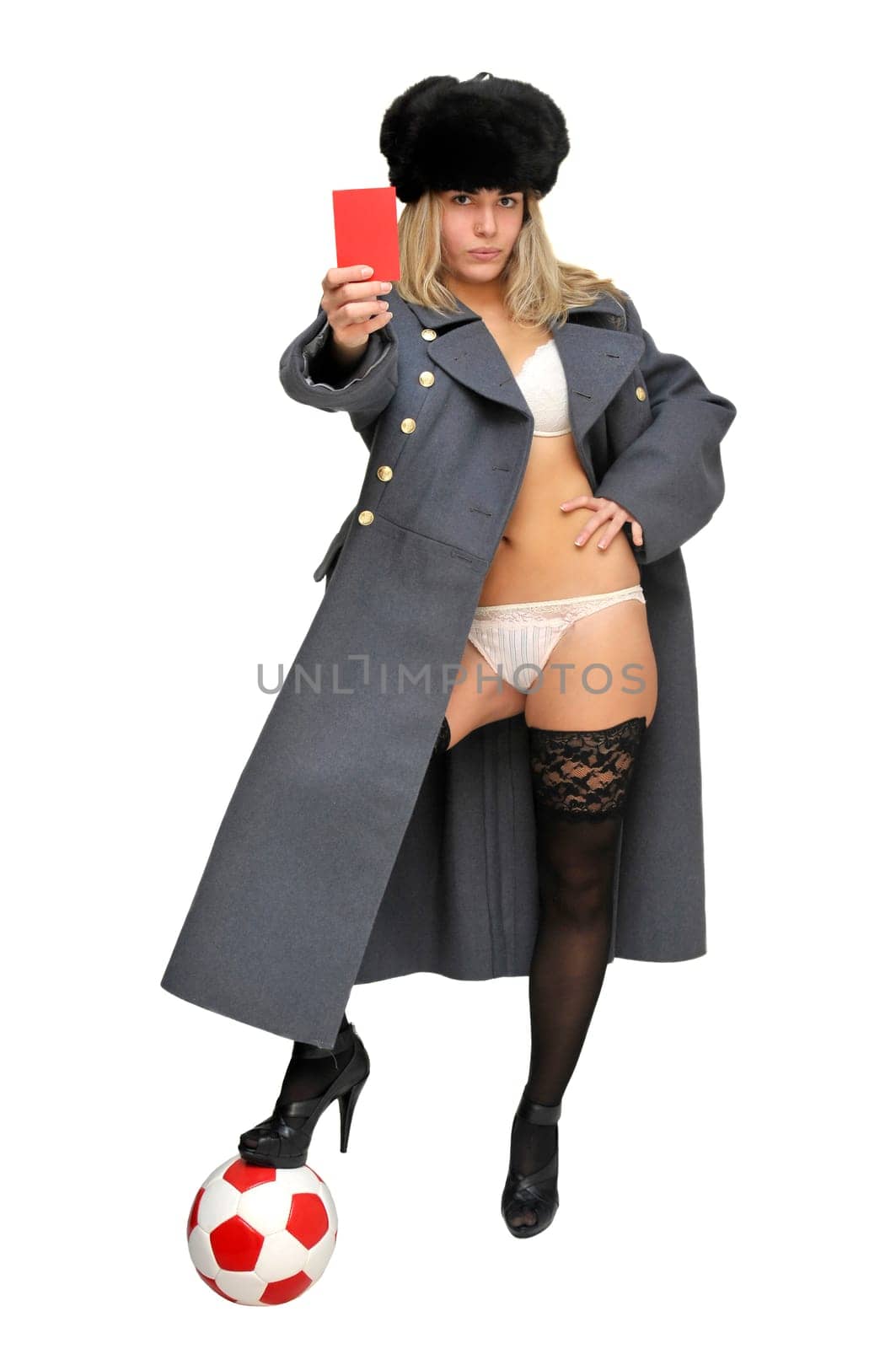 Sexy girl in russian army greatcoat holding a soccer ball and a red card isolated in white