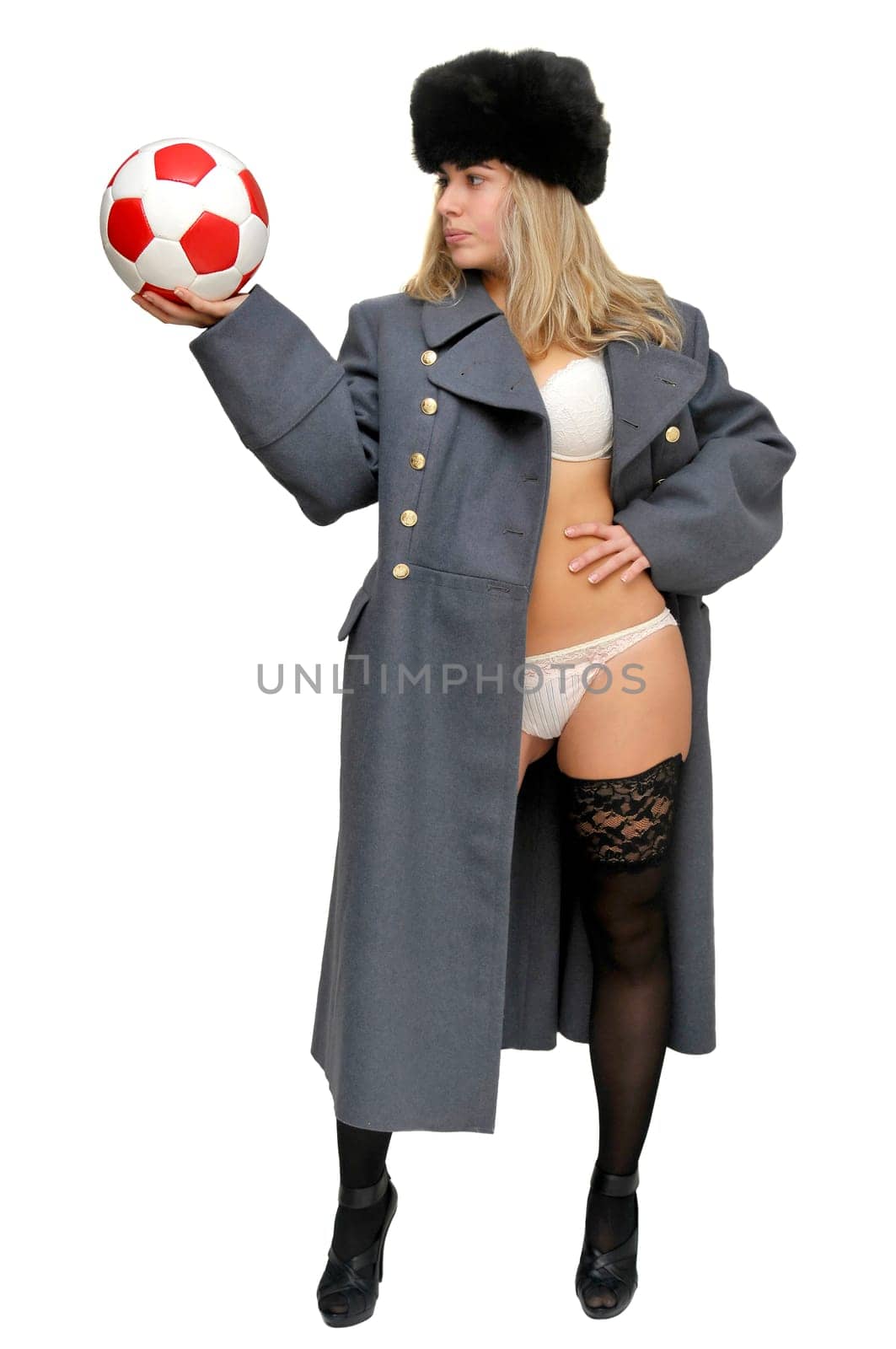 Sexy girl in russian army greatcoat and lingerie holding a soccer ball isolated in white