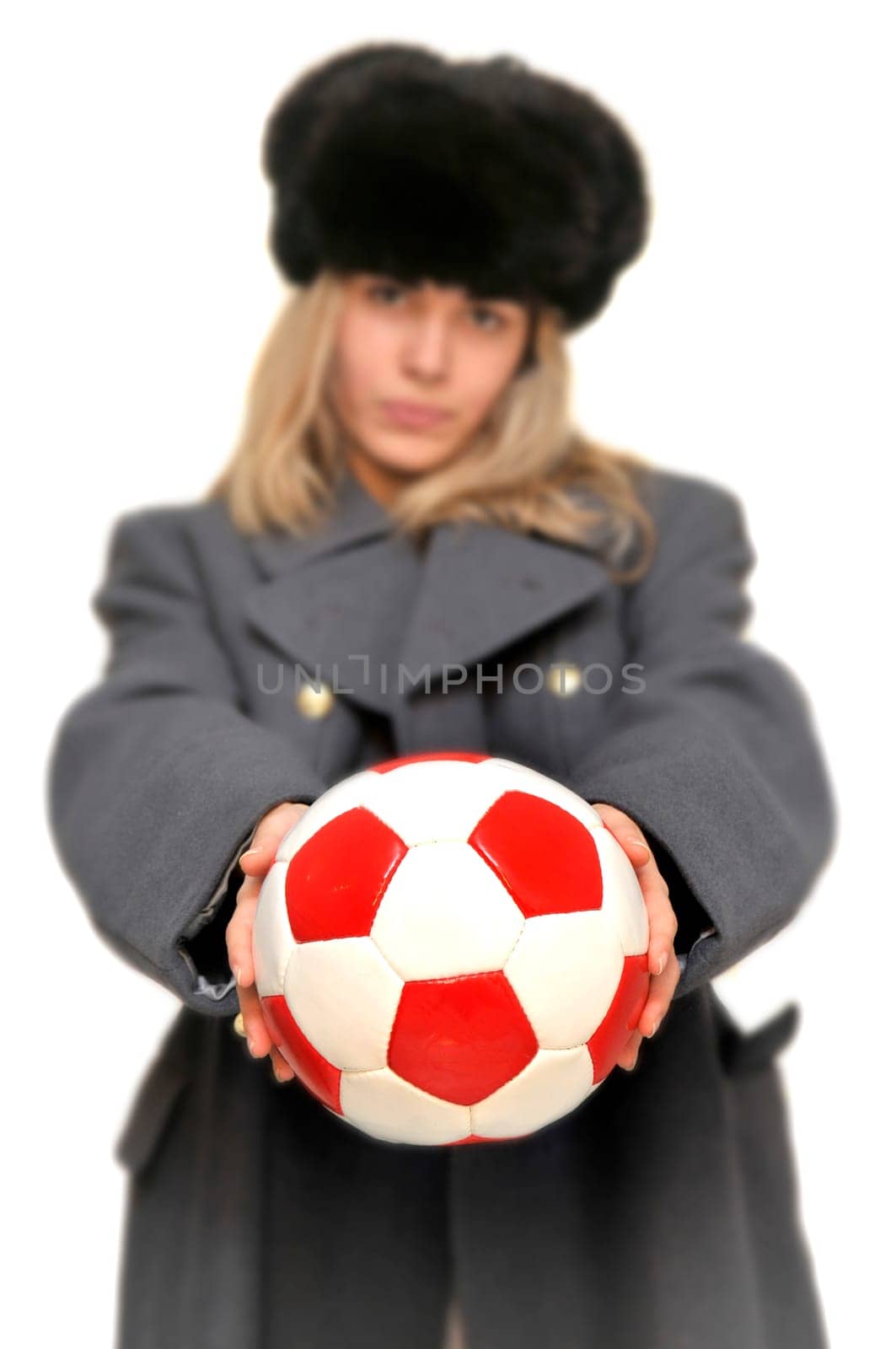 Out of focus girl in russian army greatcoat and lingerie holding a soccer ball isolated in white