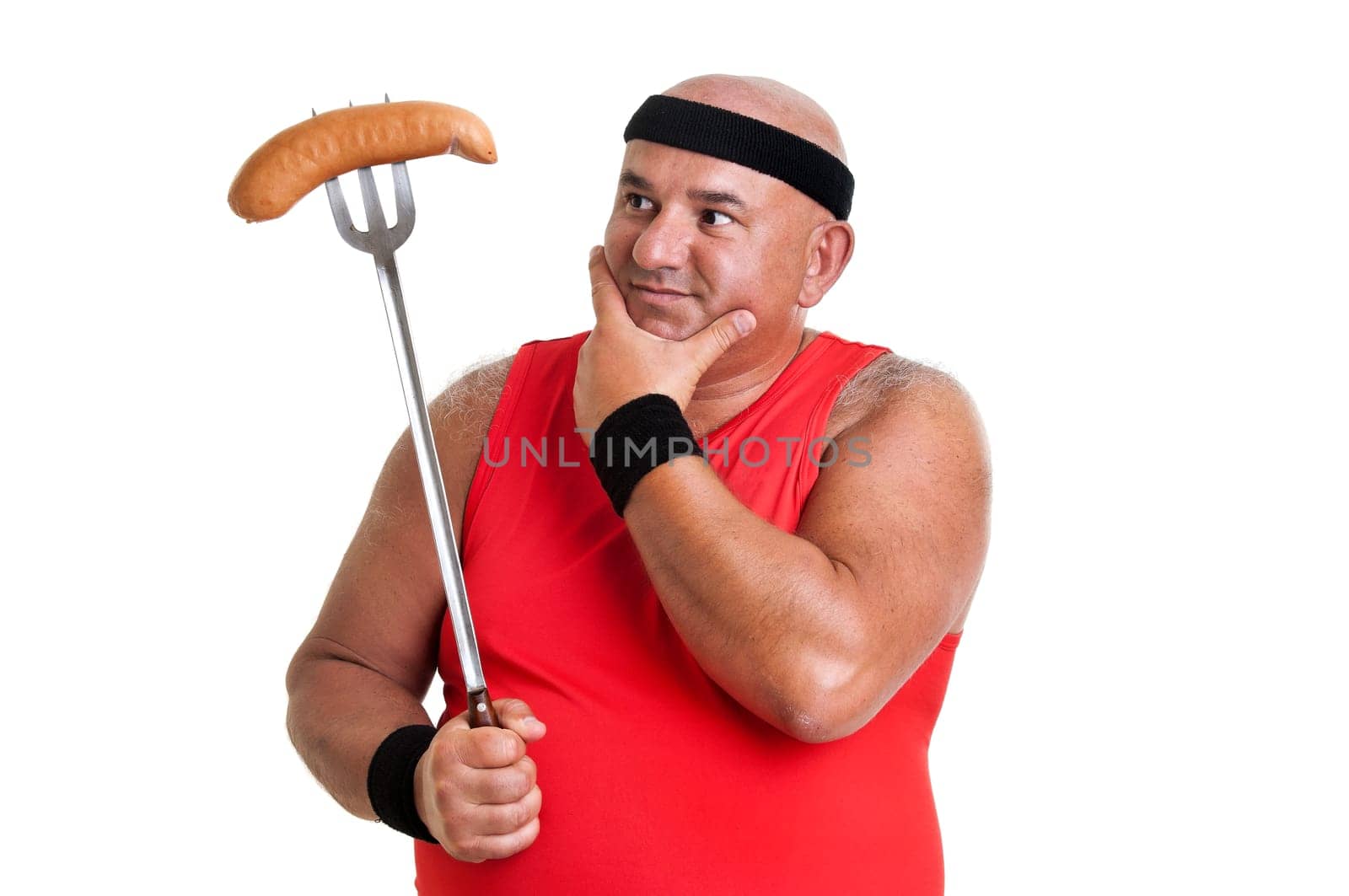 Large fitness man looking at a big sausage isolated in white