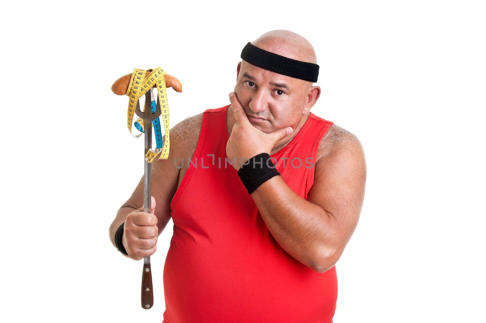 Large fitness man looking at a big sausage isolated in white