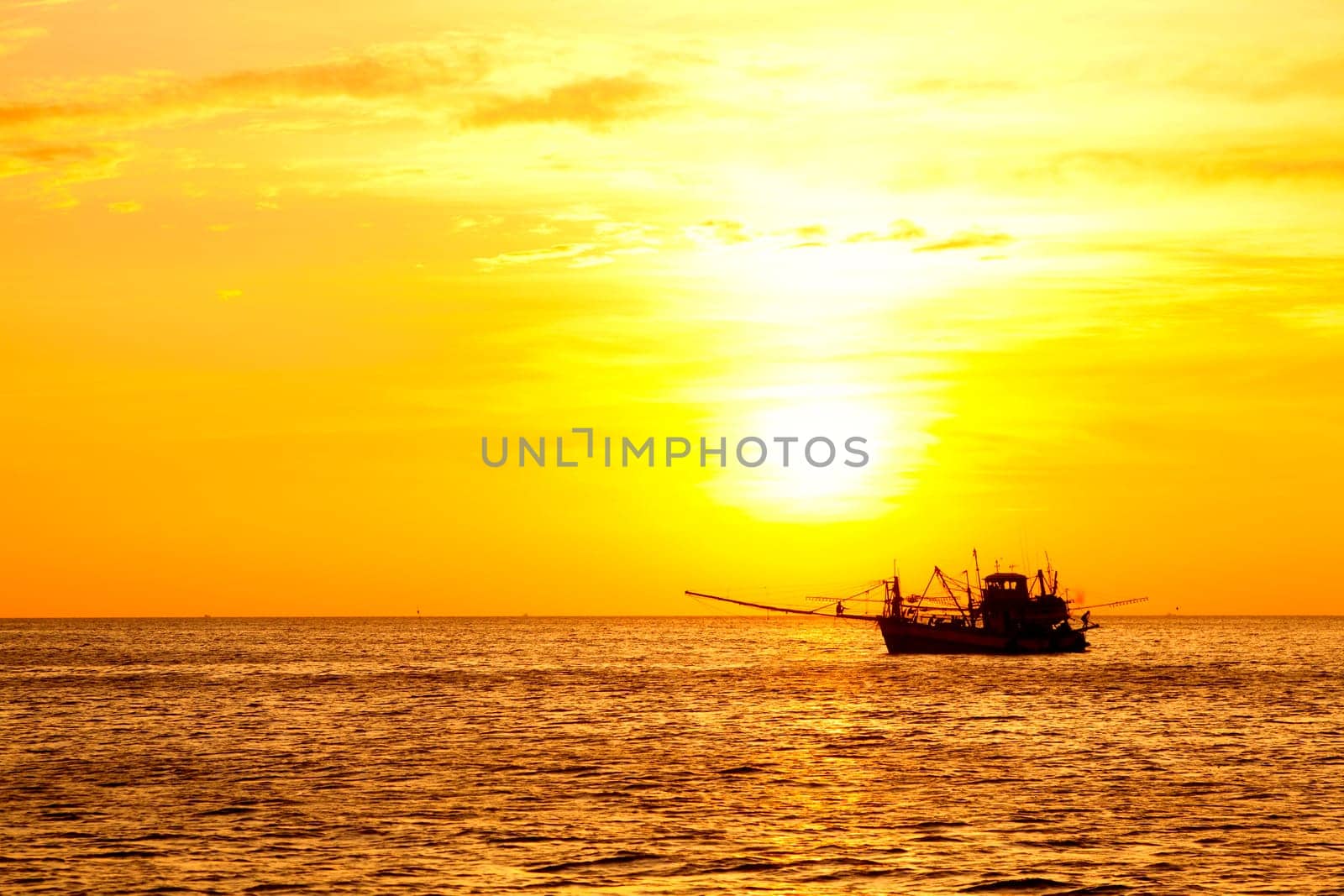 Image of a  fishing boat in the ocean at sunset