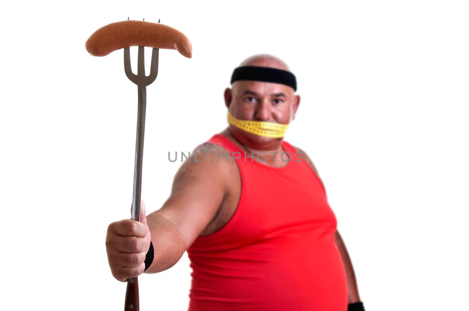 Large fitness man looking at a big sausage isolated in white
